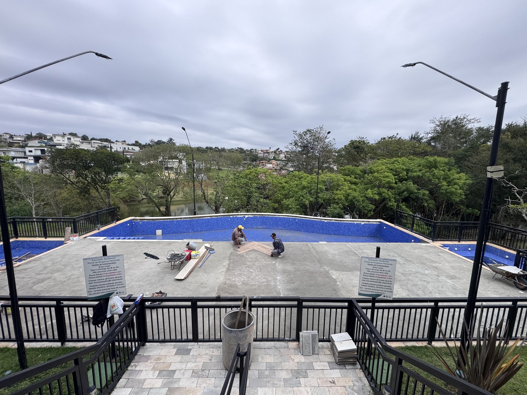 Equipe preparando a base do piso na área interna da piscina