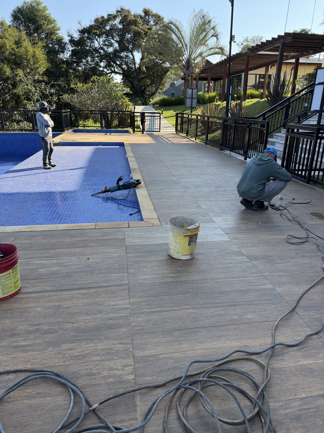 Equipe trabalhando na área externa junto à piscina social